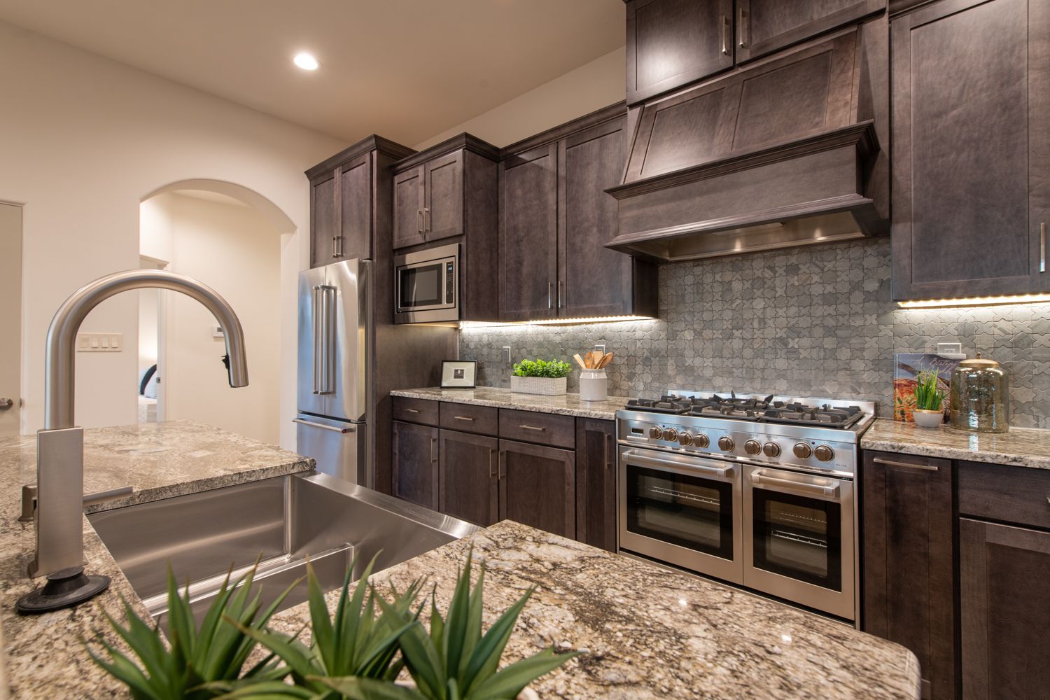 Stainless steel professional appliances, granite countertops, and custom stone inlay backsplash